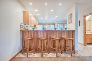 a kitchen with a bar with four stools at Beach Break in Pacific City