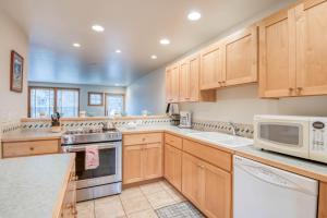 a kitchen with wooden cabinets and white appliances at Beach Break in Pacific City