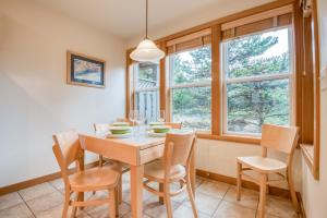 a dining room with a table and chairs and windows at Beach Break in Pacific City