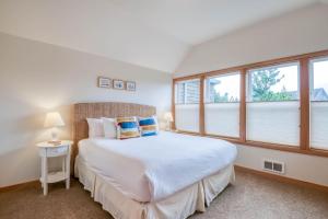 sypialnia z dużym białym łóżkiem i oknami w obiekcie Beach Break w mieście Pacific City