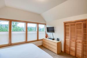 a bedroom with a bed and a tv and windows at Beach Break in Pacific City