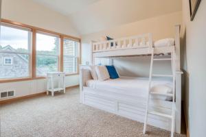 a bedroom with two bunk beds and two windows at Beach Break in Pacific City