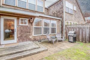 a patio with two chairs and a grill in front of a house at Beach Break in Pacific City
