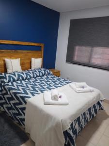 a bedroom with a bed with two towels on it at CASA por temporada en Yerba Buena/Tucumán in Yerba Buena