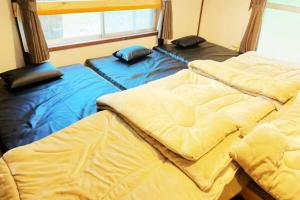 two beds sitting next to each other in a room at ガチンコBBQロッジ北軽井沢 in Tsumagoi