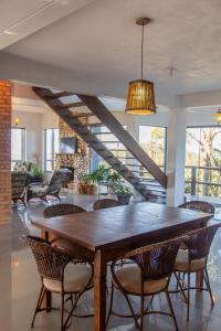 a dining room with a wooden table and chairs at Casa do Morro in Praia do Rosa