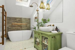 La salle de bains est pourvue d'une baignoire blanche, d'un lavabo et d'une baignoire. dans l'établissement Wembley Cottage, Southern Highlands, à Berrima