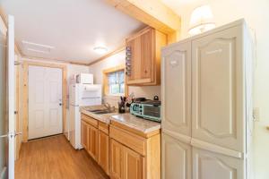 a kitchen with wooden cabinets and a white refrigerator at Moss Quadrant in Rockaway Beach