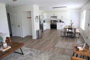 a kitchen and living room with white cabinets and a table at 5-BR Serene Retreat Near CLE* Dogs welcome! in Berea