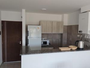 a kitchen with a refrigerator and a counter top at Moderno Departamento en Alta Gracia in Alta Gracia