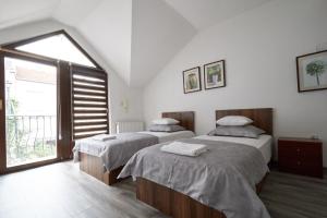 a bedroom with two beds and a large window at Vila Selma in Sarajevo