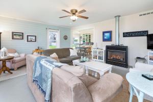 un salon avec un canapé et une cheminée dans l'établissement Serenity Cottage, à Rockaway Beach