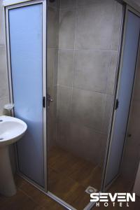 um chuveiro com uma porta de vidro ao lado de um lavatório em Seven Hotel - Juana Koslay San Luis em Juana Koslay 