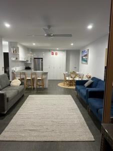 a living room with two couches and a dining room at Ebbtide 22 in Forster
