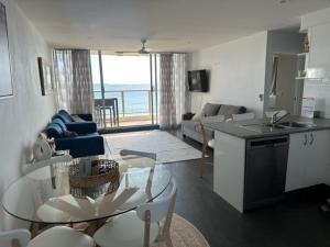 a kitchen and living room with a view of the ocean at Ebbtide 22 in Forster