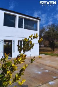 a white building with yellow flowers in front of it at Seven Hotel - Juana Koslay San Luis in Juana Koslay 