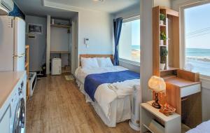 a bedroom with a bed with a view of the ocean at Sometimes Jeju in Jeju