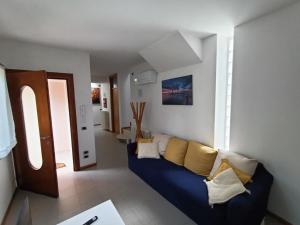 Il Nido - Villetta in posizione strategica في تريفيزو: غرفة معيشة مع أريكة زرقاء مع وسائد صفراء