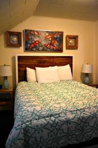 a bedroom with a bed with two lamps and two paintings at Sand Dollar in Seaside