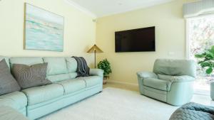 una sala de estar con un sofá y una silla en Honeysuckle Rose Retreat, en Shoreham