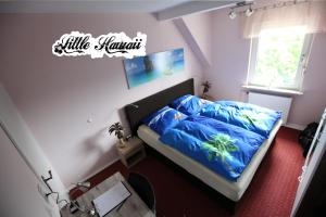 a bedroom with a bed with a blue comforter at Little Hawaii & Texas in Bad Wildungen