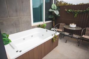 a bath tub sitting next to a patio with a table at Siyoung's House in Jeju