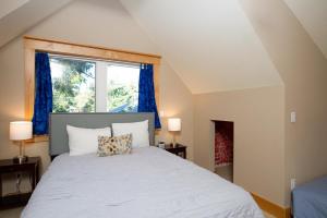 林肯市Schooner Creek Retreat的一间卧室设有一张大床和窗户