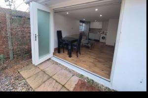 a room with a table and chairs and a kitchen at Studio with own Garden in London