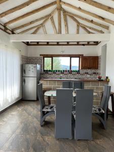 cocina con mesa y nevera en Tres habitaciones en la cabaña Quinta Buenos Aires, en Villa de Leyva