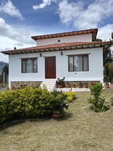 Casa blanca con techo rojo en Tres habitaciones en la cabaña Quinta Buenos Aires, en Villa de Leyva