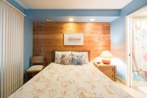 1 dormitorio con 1 cama y pared de madera en Admiral 3, en Depoe Bay