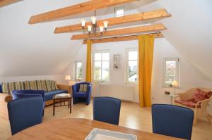 ein Wohnzimmer mit blauen Stühlen und einem Tisch in der Unterkunft Alte Büdnerei - Apt. 02 in Ostseebad Sellin