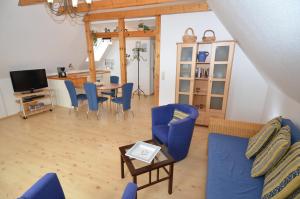ein Wohnzimmer mit blauen Stühlen und einem Tisch in der Unterkunft Alte Büdnerei - Apt. 02 in Ostseebad Sellin