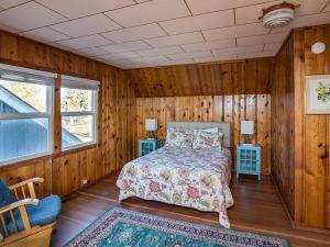 a bedroom with wooden walls and a bed in a room at Steve's Getaway in Seaside
