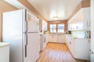 a kitchen with white cabinets and a refrigerator at Surfers Cove in Seaside