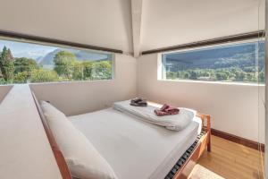 niewielka sypialnia z łóżkiem i dużym oknem w obiekcie Splendido attico per chi ama escursioni nella natura w mieście Grono