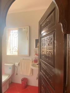 a bathroom with a toilet and a window and a door at Résidence Palmariva Aglou in Tiznit