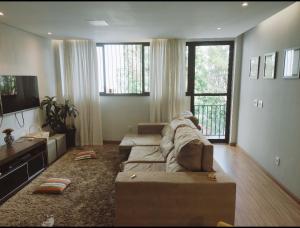 a living room with a couch and a television at Hidro, piscina aqc, próx savassi in Belo Horizonte
