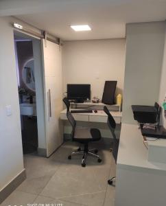 an office with a desk with a computer and two chairs at Hidro, piscina aqc, próx savassi in Belo Horizonte +20 photos