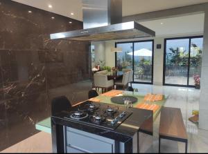 a kitchen with a stove and a dining room at Hidro, piscina aqc, próx savassi in Belo Horizonte