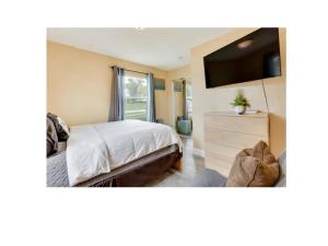 a bedroom with a bed with a tv and a dresser at El SHADDAI in Orlando