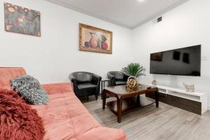 a living room with a couch and a flat screen tv at Serenity Haven SOCo2BR/2BA DTATX in Austin