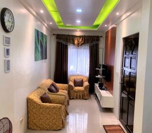 un soggiorno con due sedie e un orologio sul soffitto di The Ideal Place in Cauayan city a Cauayan