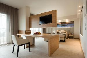 a living room with a desk and a bedroom at Laguna Park Hotel 4Superior in Bibione +37 photos