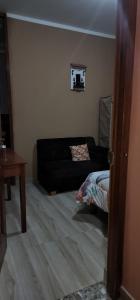 sala de estar con sofá negro y mesa en Hostal El Ángel, en Chachapoyas