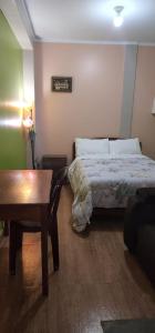 Un dormitorio con una cama y una mesa. en Hostal El Ángel en Chachapoyas