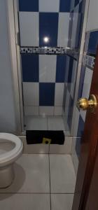 łazienka z toaletą i niebiesko-białymi kafelkami w obiekcie Hostal El Ángel w mieście Chachapoyas