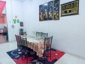 ein Esszimmer mit einem Tisch und 4 Stühlen in der Unterkunft Teres luas & selesa, dekat shopping mall, UMT in Kuala Terengganu