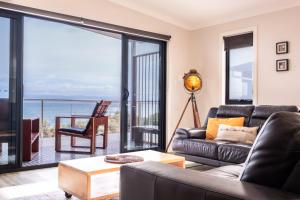 a living room with a couch and a view of the ocean at Whale Watcher 2 in Coles Bay