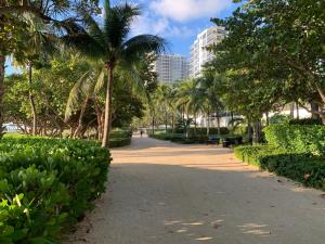 a park with palm trees and a sidewalk at Biscayne Garden's Studio in Miami